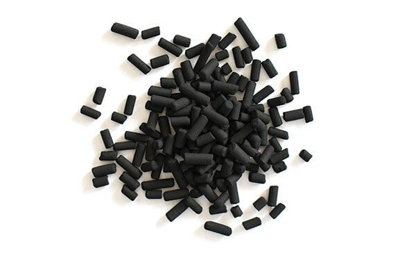 A pile of black activated carbon pellets, cylindrical in shape, used for aquarium filtration to remove impurities, odors, and toxins from water.